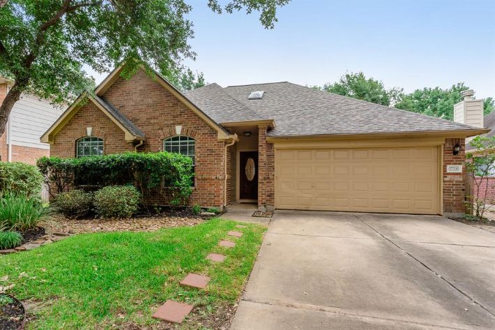 A brick house with a driveway and garage.