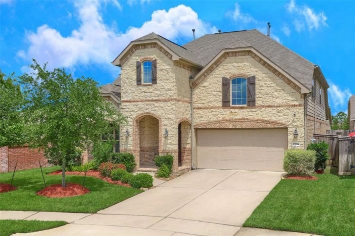 A large brick home with a driveway and garage.