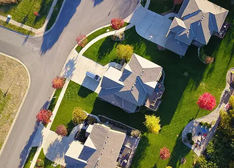 A bird 's eye view of houses on the grass.