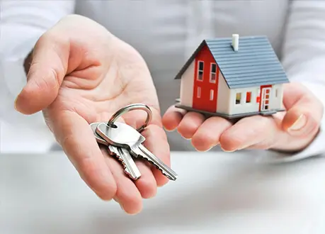 A person holding out their hands with keys in front of them.