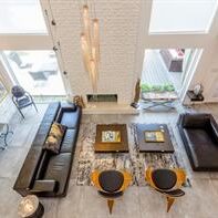 A living room with two black couches and a fireplace.