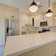 A kitchen with white cabinets and stainless steel appliances.